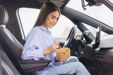 Young Woman Enjoying Healthy Lunch Inside Her Car, Embracing Convenient On the Go Lifestyle with...