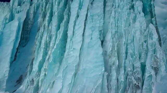 Seracs of a turquoise glacier are reflecting in calm water in a polar region. The glacier ice is showing the effects of global warming