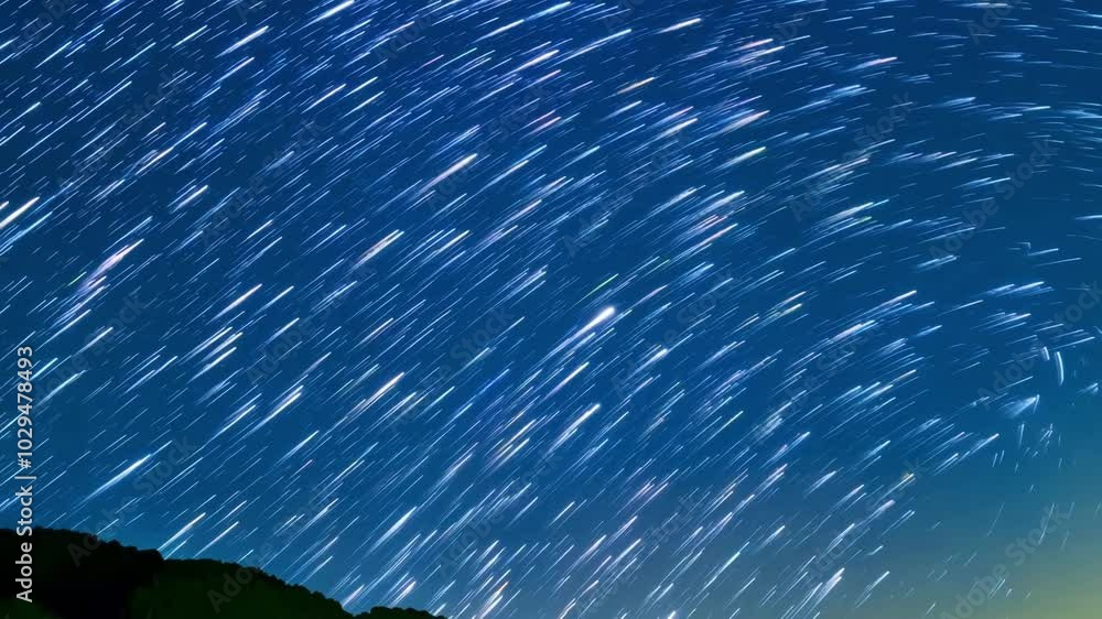 Poster Long exposure capturing the movement of stars across the night sky, creating streaks of light against a deep blue backdrop