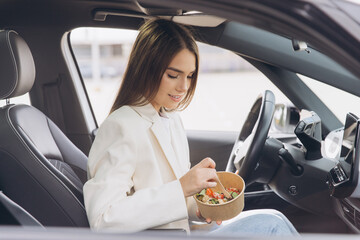 Young Woman Enjoying Healthy Lunch in Car While Commuting to Work During Busy Weekday
