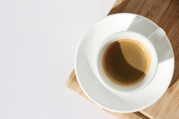Fresh Espresso in White Cup on Wooden Board, Top View.