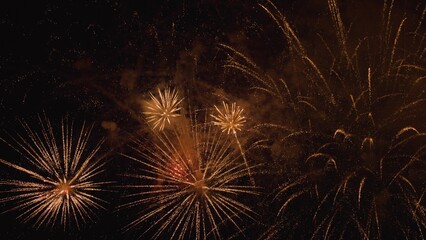 New years eve fireworks celebration. Glowing fireworks show. Beautiful multi colored fireworks in night sky. Shining fireworks with bokeh lights in night sky. Colored night explosions in black sky