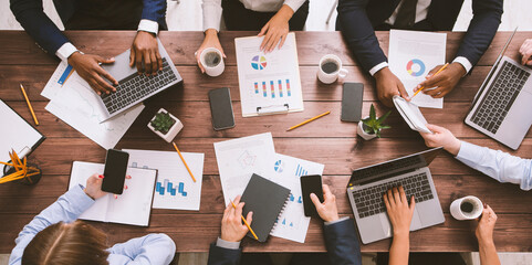 Brainstorm discussion. Meeting of business team working with gadgets and documents, top view