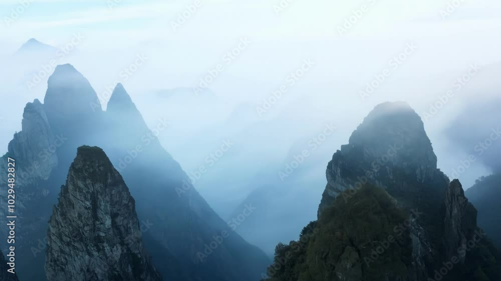 Aufkleber Majestic mountain peaks are shrouded in a mystical fog, creating an ethereal and serene landscape that evokes a sense of tranquility and awe