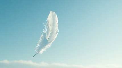   A white feather floats against a clear blue sky background without clouds