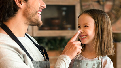 Cheerful Little Girl And Her Young Dad Having Fun In Kitchen Together, Fooling While Baking Pastry...