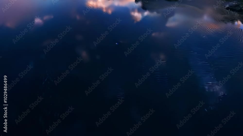 Poster The serene sunset reflection on water creates a colorful and calming scene from above, perfect as a peaceful background