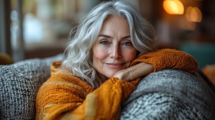A serene older woman enjoys a cozy evening at home in a warmly lit living room with soft furnishings