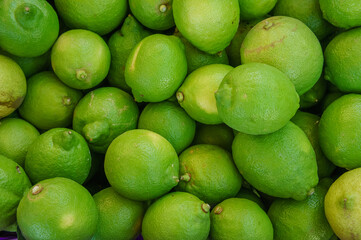Freshly Harvested Limes Piled Together at a Vibrant Local Market in the Afternoon Sunlight, Showcasing Their Bright Green Hues
