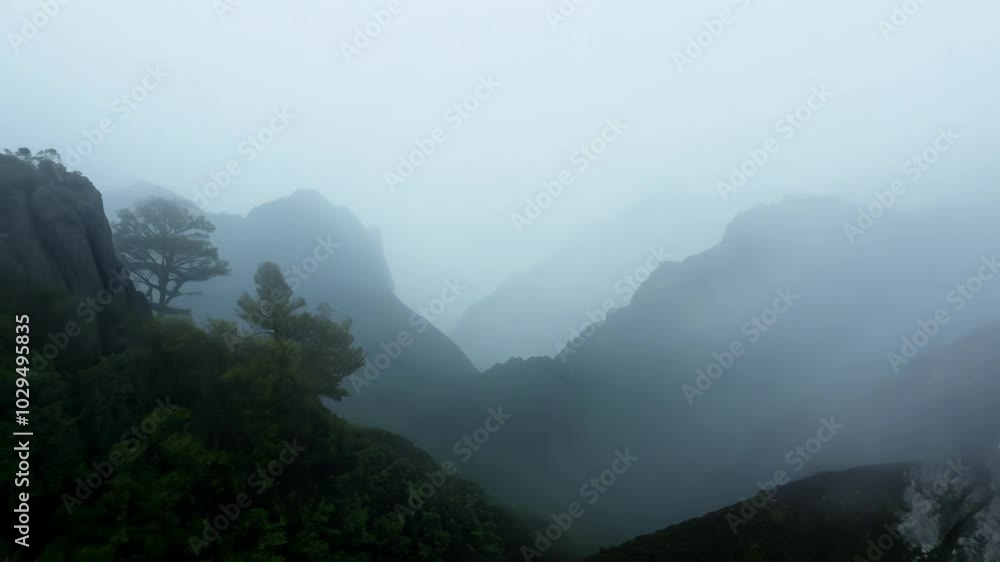 Aufkleber fog is rolling over the tops of a mountain range, creating a mysterious and beautiful scene. the lus