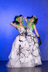 Two girls in scary wedding dresses with black web, green hair and head decorations. Scary Halloween...
