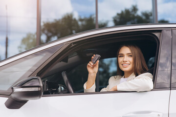 Young Woman Smiling Holding Car Key Inside Modern Vehicle