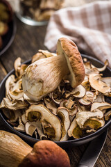 Dried porcini mushrooms. Sliced boletus on plate on wooden table.