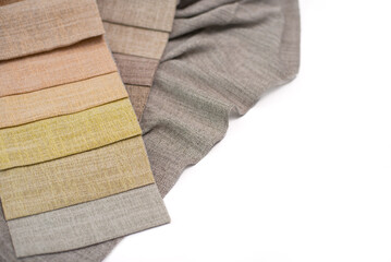 Samples of textured linen fabric for curtains in warm colors on a white background.