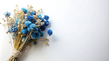 White background with dried blue flowers in a blue bouquet arrangement at a tilted angle