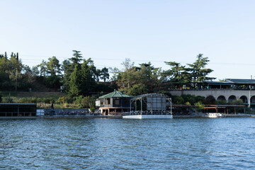Obraz premium lake with blue water, and trees and buildings on the shore, Turtle Lake in Tbilisi
