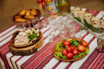 Traditional Ukrainian cuisine with lard, bread, vegetables, and meat on embroidered tablecloth