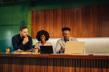 Diverse staff with laptop running research for green technology using.