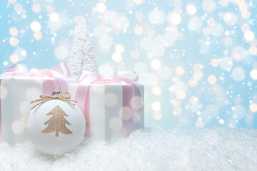 Creative composition with Christmas gift boxes and bauble decoration on abstract bokeh background. Minimal Christmas or New Year concept.