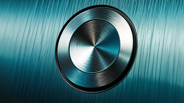 A close-up view of a round, metallic button on a teal surface