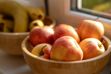 Wooden bowls full of organic apples and bananas from the farmers market