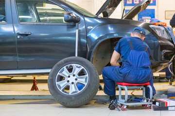 Changing car brake pads by mechanic in car repair workshop