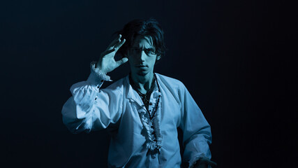 A dramatic hero in a white vintage blouse makes spectacular poses, a portrait in the moonlight