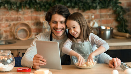 Cute Little Girl And Her Dad Checking Recipe On Digital Tablet While Cooking Pastry In Kitchen Together, Little Girl Kneading Dough, Closeup