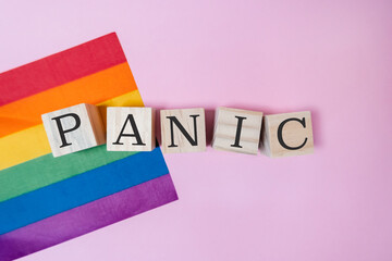 Rainbow flag and a wooden block with the word panic written on it