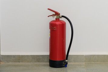 Red fire extinguisher on tile floor