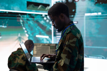 Serviceman coordinating army recruits for a complex military operation, ensuring all troopers units...