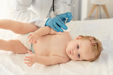 Child's immunization, health concept. Doctor pediatrician vaccinating baby girl in clinic, closeup shot