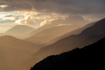 Sunset in the mountains on the island of Crete, Greece. The hills fade into the distance with a...