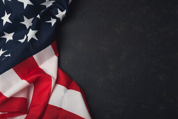 A red and white American flag is draped over a black background