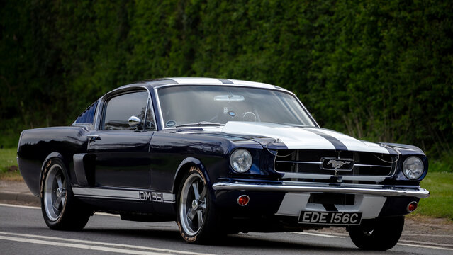 1965 Ford Mustang car travelling on an English country road