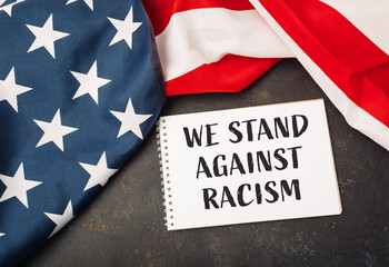 White piece of paper with the words We stand against racism written on it