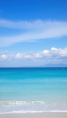 a blue ocean and a white beach with a blue sky