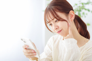スマホを見て冴えない表情をする女性