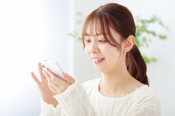 スマホを操作する笑顔の女性