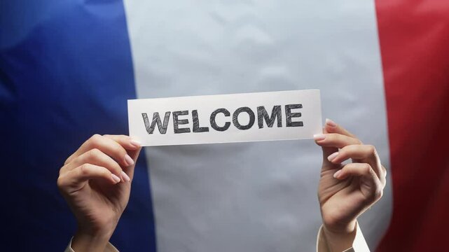 Woman with Welcome lettering title text cardboard on french flag background. France, greeting card, banner