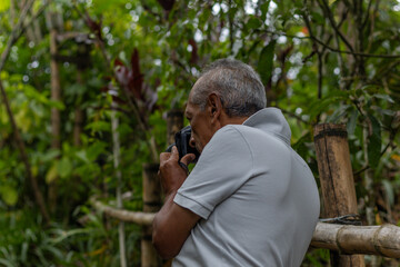 Senior nature photographer on mountain - professional photographer taking photos of nature in the forest