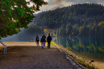 A group of 4 people who take the trail around Westwood Lake Park during the autumn 2024, Nanaimo, Vancouver Island, British Colombia, Canada
