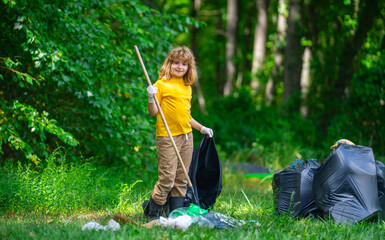 Kid cleaning up the park, putting trash in a garbage bag. Environmental protection. Child Picking...
