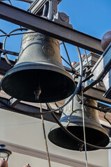 Ancient church bells hanging in a metal structure on blue sky