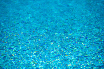 Blue pool water background. Blurred transparent clear calm water surface texture. Water waves in sunlight with copy space.