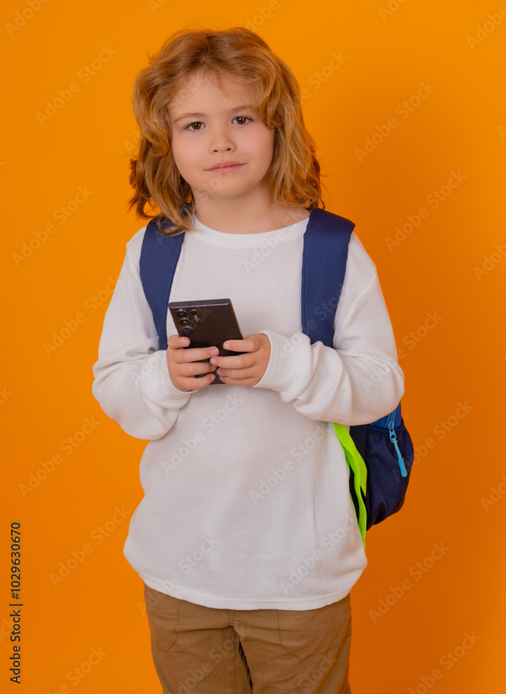Aufkleber School child sending message texting using smarpthone over yellow isolated background.