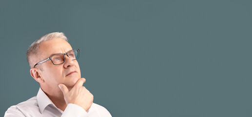 Making Decision. Close up portrait of pensive mature man in specs looking at copy space isolated...