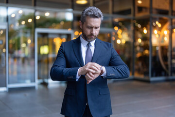 Punctual businessman checking time outdoor. Business deadline. Businessman late for business...
