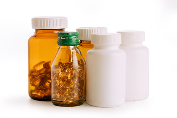 Close up of Bottle and pills. Supplement capsule gels in jar and prescription cure pills plastic container on white background.