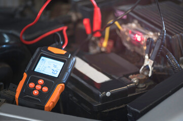 Car digital battery tester  on white background. Diagnostic tool.
